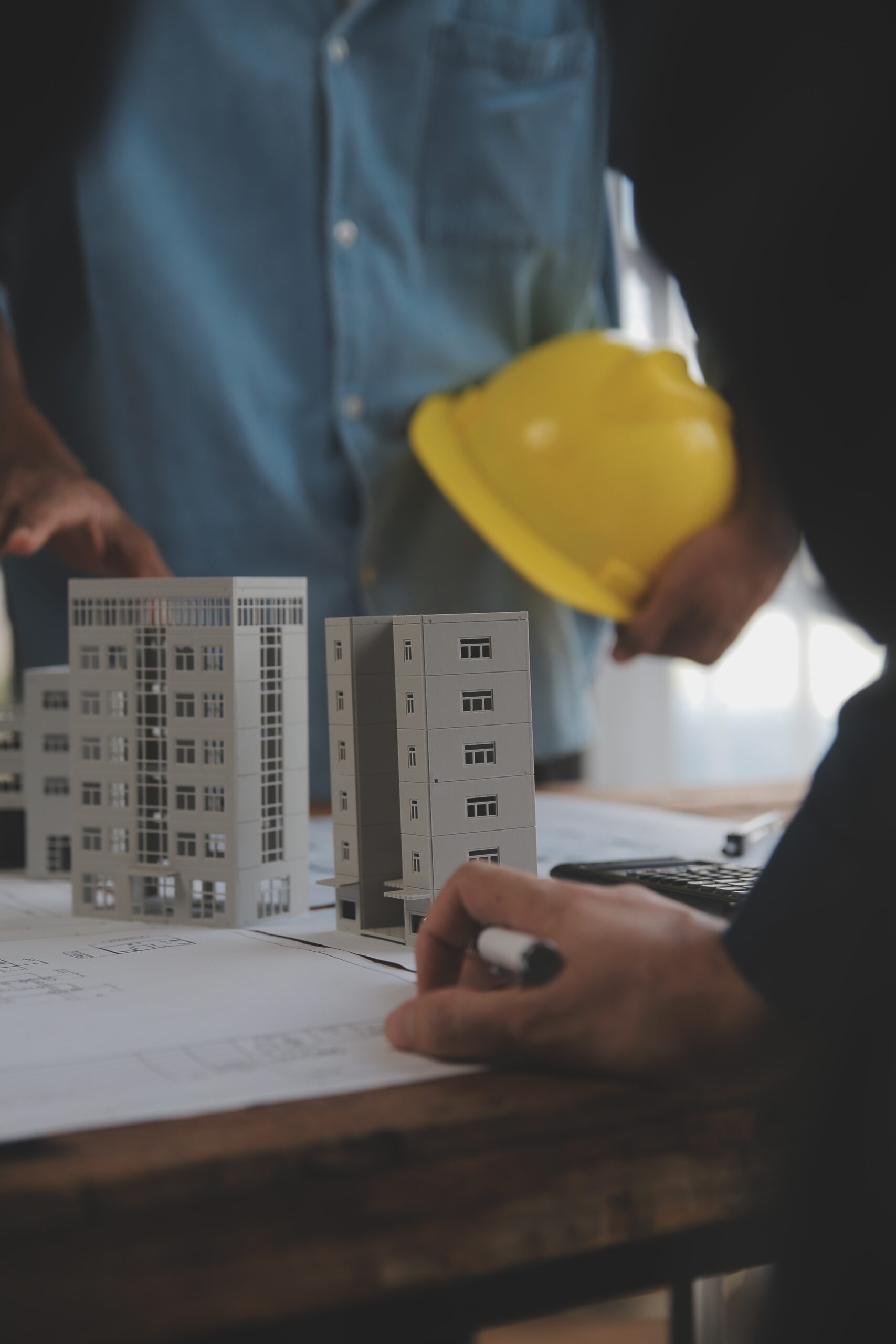 construction and structure concept of engineer or architect meeting for project working with partner and engineering tools on model building and blueprint in working site, contract for both companies.