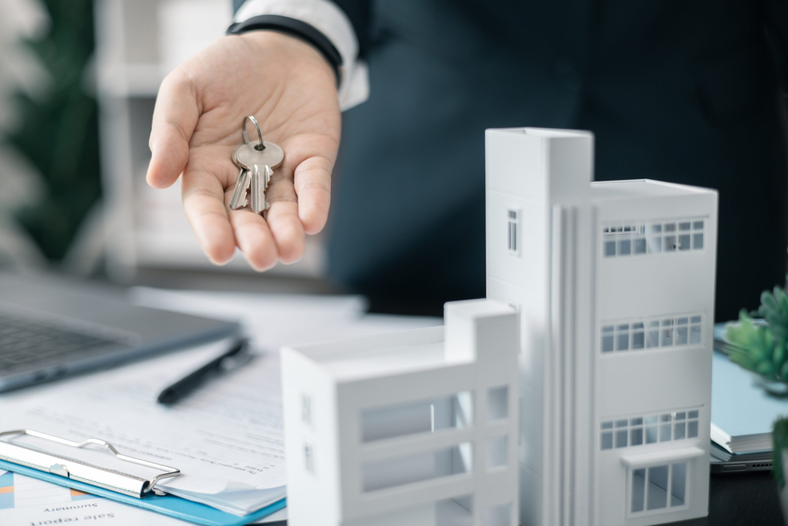 real estate agent handed over the key to new home, marking a successful investment in business of property, whether it be a house or an apartment. real estate agent giving house key to customers.
