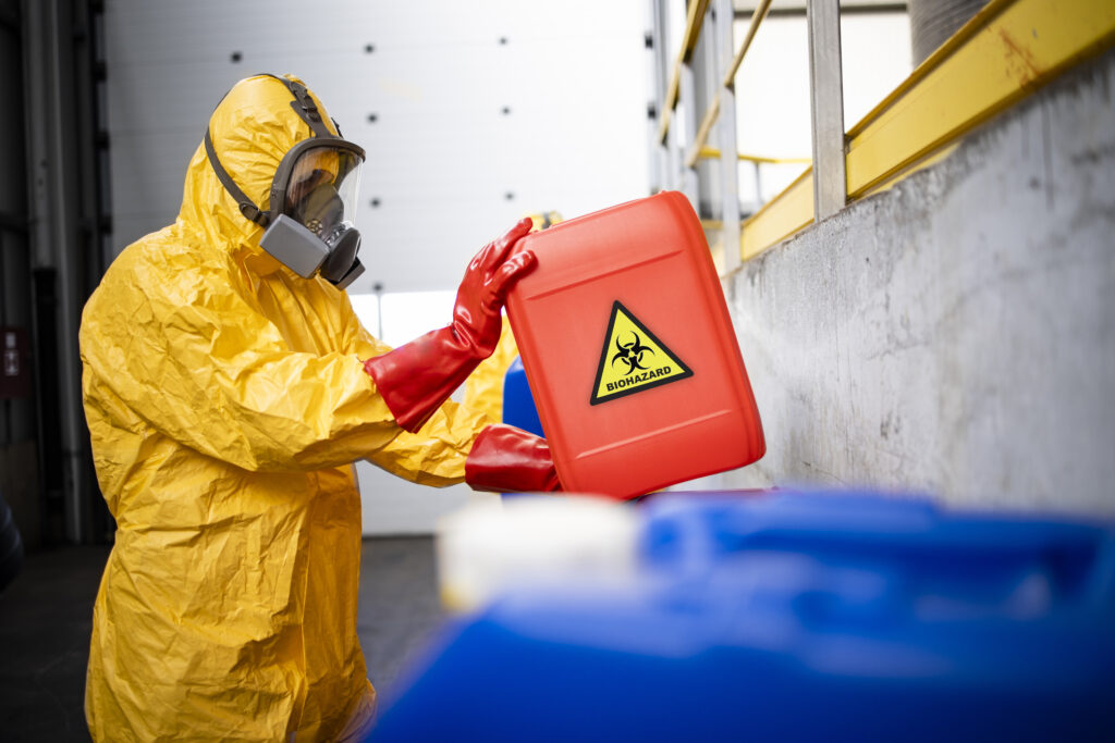 working in chemicals industry. professional worker in hazmat protection suit and gas mask working with dangerous and toxic materials.