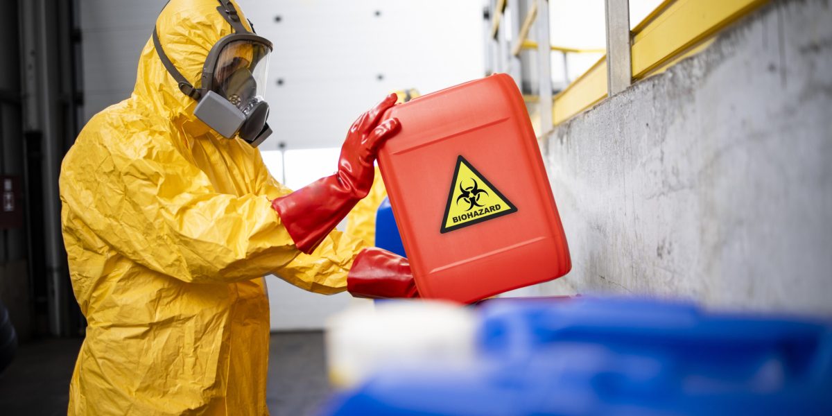 working in chemicals industry. professional worker in hazmat protection suit and gas mask working with dangerous and toxic materials.